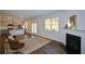 Bright living room featuring fireplace, hardwood floors, and stainless steel appliances in adjacent kitchen at 67 Highgrove Way, Dallas, GA 30157