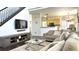 Open-concept living room with dark hardwood floors, a modern TV console, and a view of the kitchen at 2674 Misty Rock Cv, Dacula, GA 30019