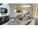Bright living room with a large sectional sofa, a modern TV, and an open view into the kitchen at 2674 Misty Rock Cv, Dacula, GA 30019