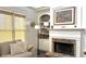 Living room showcasing a stone fireplace, built-in shelving, and a comfortable sofa near a window at 2674 Misty Rock Cv, Dacula, GA 30019