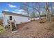 Backyard with stairs leading to the house, wooded backdrop, and fallen leaves throughout the yard at 306 Birch St, Canton, GA 30114