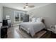 Bedroom features a ceiling fan, natural light, decorative armoire, hardwood floors and neutral walls at 2077 Towne Mill Ave, Canton, GA 30114
