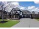 Stunning two-story home with a three-car garage, stone accents, and lush green lawn at 2077 Towne Mill Ave, Canton, GA 30114