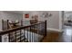 Upstairs landing with wood railing, hardwood floors, neutral walls and access to multiple rooms at 2077 Towne Mill Ave, Canton, GA 30114
