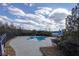 Outdoor swimming pool with surrounding patio, landscaping, and slide under a blue sky and scattered clouds at 2077 Towne Mill Ave, Canton, GA 30114