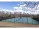 Outdoor tennis courts with lighting surrounded by a fence under a partly cloudy blue sky at 2077 Towne Mill Ave, Canton, GA 30114