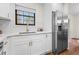 Bright kitchen featuring white cabinets, stainless steel refrigerator, and a window for natural light at 7316 Caribou Trl, Riverdale, GA 30296
