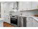 Modern kitchen showcasing stainless steel appliances, white cabinetry, and stylish backsplash, with an oven and dishwasher at 7316 Caribou Trl, Riverdale, GA 30296