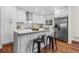 Modern kitchen featuring white cabinets, stainless steel appliances, a stylish backsplash, and an island with seating at 7316 Caribou Trl, Riverdale, GA 30296