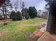 Large backyard featuring green grass, gravel, and mature trees at 1007 Billy Mcgee Rd, Lawrenceville, GA 30045