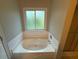 Modern bathtub with tiled walls, providing a serene and spa-like bathing experience at 1007 Billy Mcgee Rd, Lawrenceville, GA 30045