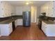 Well-lit kitchen with stainless steel appliances, granite countertops, and wood flooring at 1007 Billy Mcgee Rd, Lawrenceville, GA 30045