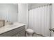 Bathroom with marble top vanity, a framed mirror, toilet, and white shower curtain at 1312 Stanley Park Dr, Decatur, GA 30033