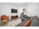 Living area with grey sofa, wood floors, TV, and an orange accent chair at 1312 Stanley Park Dr, Decatur, GA 30033