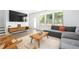 Bright living room has hardwood floors, a gray sectional, and mid-century modern furniture at 1312 Stanley Park Dr, Decatur, GA 30033