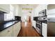 Bright kitchen featuring white cabinets, stainless appliances, dark countertops, and hardwood floors at 338 Clifford Ne Ave, Atlanta, GA 30317