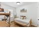 Bedroom features white walls, wood floors, a rattan bed and desk area with good light at 1995 Sumter Nw St, Atlanta, GA 30318