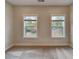 Bright bedroom featuring neutral walls, carpet flooring, two windows, and ample natural light at 2461 Sycamore Nw Rd, Atlanta, GA 30318
