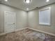 A cozy bedroom with carpet, a window with blinds, and a neutral color scheme at 2461 Sycamore Nw Rd, Atlanta, GA 30318