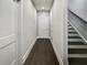 Hallway with dark wood floors leading to a white door and staircase, enhancing the home's modern appeal at 2461 Sycamore Nw Rd, Atlanta, GA 30318