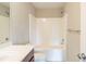 Bright bathroom featuring a white shower-tub combo and a cherry vanity with brushed nickel accents at 2819 Hillside Way, Decatur, GA 30034