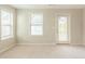 Bright bedroom with neutral carpet, a door to the outside, and natural light from two windows at 2819 Hillside Way, Decatur, GA 30034