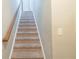 Carpeted stairway featuring a wood railing and white trim, leading to the upper level of the home at 2819 Hillside Way, Decatur, GA 30034