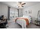 Neutral bedroom with ceiling fan, natural light, and simple furnishings including desk and mirror at 514 Cunninghame Ct, Peachtree City, GA 30269