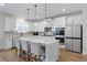 Well-lit kitchen with stainless steel appliances, lots of cabinets, counter seating, and pendant lighting at 514 Cunninghame Ct, Peachtree City, GA 30269