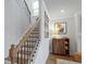 Carpeted staircase with stained handrail and black metal balusters, with modern accent wall art at 514 Cunninghame Ct, Peachtree City, GA 30269