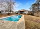 Backyard shot of an in-ground pool, wood deck and partially fenced yard under a sunny sky at 5281 Brookshire Ct, Douglasville, GA 30135