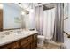 Classic bathroom with wood vanity, marble countertops, and shower with grey shower curtain at 6325 S Summers S Cir, Douglasville, GA 30135