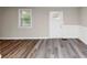 Bright room with modern flooring, wainscoting, a window with grill, and a white door at 16 Wadley Nw St, Atlanta, GA 30314