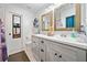 Bright bathroom features a double sink vanity with neutral countertops, cabinets and framed mirrors at 1824 Evans Sw Dr, Atlanta, GA 30310