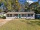 Charming single-story home featuring a brick facade, teal door, and well-maintained lawn with mature trees at 1824 Evans Sw Dr, Atlanta, GA 30310
