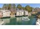 Aerial view of the community over the lake featuring community buildings and mature trees at 504 Mill Pond Ct, Smyrna, GA 30082