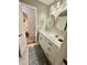 A clean bathroom with modern fixtures, double mirror, stylish sink, and a view into another room at 1044 Mariners Ct, Stone Mountain, GA 30083