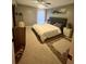 Bedroom with neutral tones, a ceiling fan, a large bed, carpet, and an area rug at 1044 Mariners Ct, Stone Mountain, GA 30083