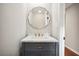 Modern powder room with elegant vanity, gold hardware, and unique round mirror at 1920 Rocky Mill Ln, Lawrenceville, GA 30044