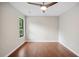 Bright bedroom with hardwood floors, ceiling fan, and window providing natural light at 1920 Rocky Mill Ln, Lawrenceville, GA 30044