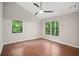 Bright bedroom featuring hardwood floors, two windows with view, and a ceiling fan at 1920 Rocky Mill Ln, Lawrenceville, GA 30044