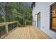 View of the wooden deck with black metal railings, and a light blue door leading into the house at 1920 Rocky Mill Ln, Lawrenceville, GA 30044