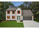 Charming two-story home with orange shutters, a gray roof, an attached two-car garage, and a beautifully landscaped yard at 1920 Rocky Mill Ln, Lawrenceville, GA 30044