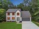 Charming two-story home with orange shutters, a gray roof, an attached two-car garage, and a beautifully landscaped yard at 1920 Rocky Mill Ln, Lawrenceville, GA 30044