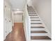 Inviting hallway with wooden floors, a white staircase, and a view into the next room at 1920 Rocky Mill Ln, Lawrenceville, GA 30044