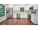 Bright kitchen featuring stainless steel appliances, white cabinets, granite countertops, and hardwood floors at 1920 Rocky Mill Ln, Lawrenceville, GA 30044