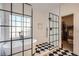 Luxurious bathroom featuring a standalone tub, sleek black framed shower, and black and white tile flooring at 3619 Elinburg Ne Ct, Buford, GA 30519