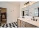 Bathroom with double vanity, quartz countertops, modern fixtures, and black and white checkerboard floors at 3619 Elinburg Ne Ct, Buford, GA 30519