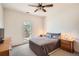 Bedroom features a window and two nightstands, a bed and a ceiling fan at 3619 Elinburg Ne Ct, Buford, GA 30519