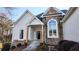 Charming front entrance with stone and stucco exterior, featuring a covered porch and landscaped garden at 3619 Elinburg Ne Ct, Buford, GA 30519